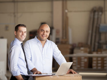 Two men working and standing at a computer