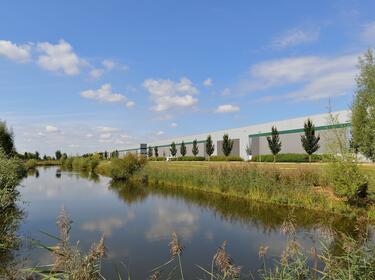 A warehouse with trees and a river in the background A warehouse with trees and a river in the background