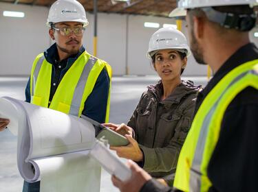 Three workers in a warehouse.
