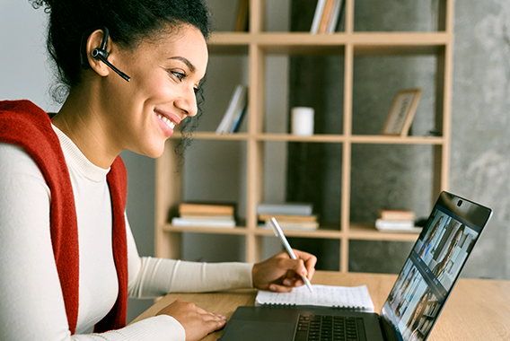 Mujer siguiendo una sesión de capacitación en línea en su laptop Mujer siguiendo una sesión de capacitación en línea en su laptop