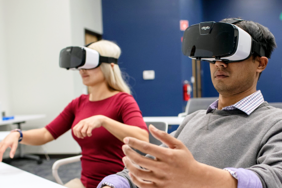 Dos personas usando un casco de realidad virtual Dos personas usando un casco de realidad virtual