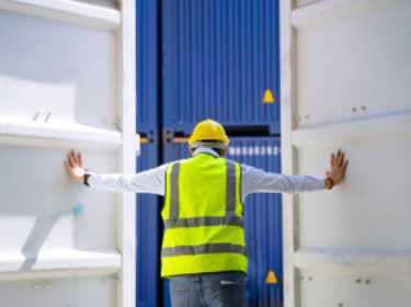 Trabajador abriendo las puertas de un contenedor de envío. Trabajador abriendo las puertas de un contenedor de envío.